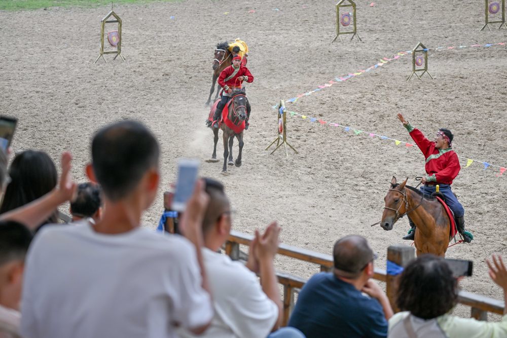 ↑8月8日，游客在内蒙古兴安盟科尔沁右翼前旗乌兰毛都草原观看马术实景剧。新华社记者 连振 摄